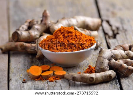 fresh turmeric roots on wooden table Royalty-Free Stock Photo #273715592