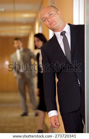 Businessman standing at door while colleagues in background