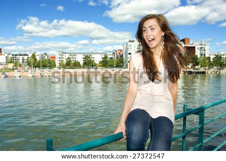 Girl sitting on a fence on the beach