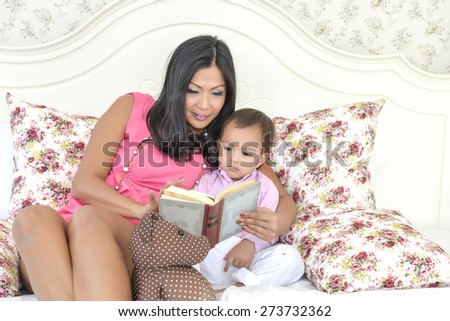 mother with baby reading cartoon book.