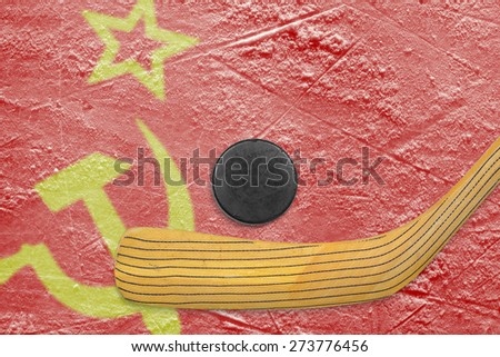 Hockey puck, hockey stick and the image of the Soviet flag on the ice