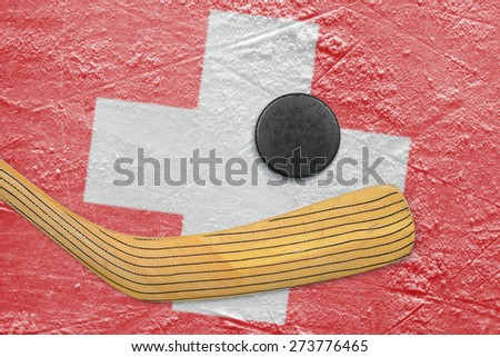 Hockey puck, hockey stick and the image of the Swiss flag on the ice