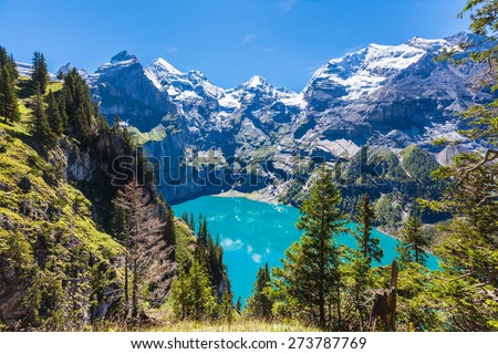 The panorama in summer view over the Oeschinensee (Oeschinen lake) and the alps on the other side near Kandersteg on bernese oberland in Switzerland. Royalty-Free Stock Photo #273787769