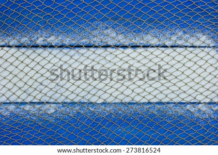 Blank ocean blue wooden beach sign with sand texture and fish net overlay