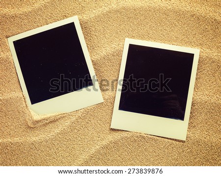 Empty photo cards in retro style  lying on a sea sand. Sunny summer background. Space for your text.