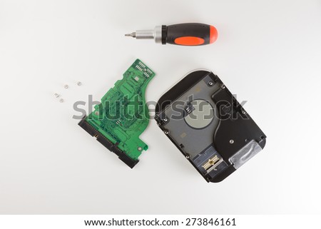 the computer hard drive in the course of dismantling on a white background
