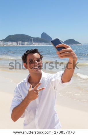 Happy latin guy making selfie at Copacabana beach