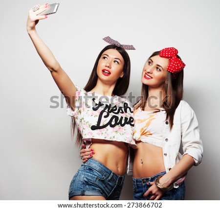 two young funny women taking selfie with mobile phone 