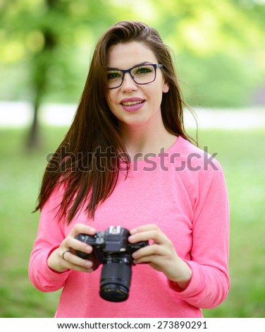 Beautiful female photographer outdoors holding camera