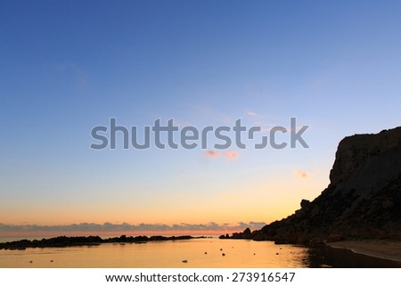 Brilliantly sunlit sky and clouds above calm surface of coastal waters in a secluded marine bay. Peacefulness, tranquility, remoteness, calm before the storm concept.  Royalty-Free Stock Photo #273916547