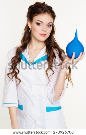 Pretty nurse girl is wearing white uniform and holding blue squirt in hands