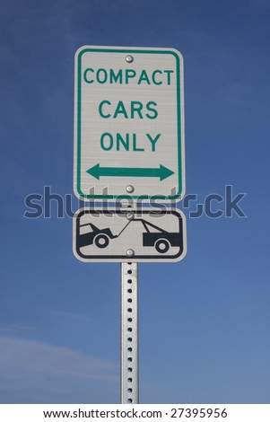 compact car only, parking and towing warning, white reflective sign against blue sky