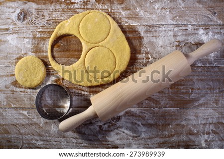 Making pastry with rolled dough and mould for baking on wooden table top in flour, horizontal picture