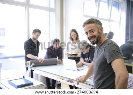 Publisher advertising agency owner working with team on a creative project. Royalty-Free Stock Photo #274000694