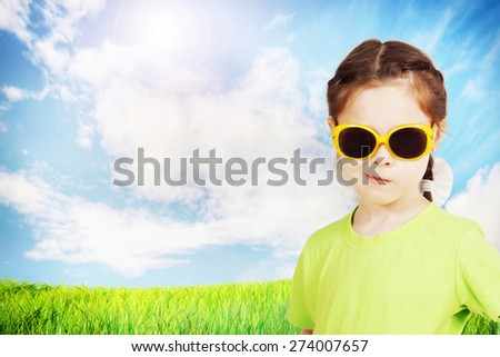 Cute little girl wearing sunglasses against bright nature background
