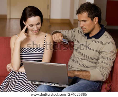 Couple using bank card online with a laptop