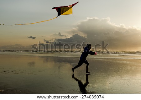 Boy with Kite at sunset on the beach in Newport, Oregon.
