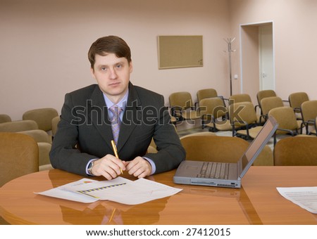 The businessman sits at a table with the laptop