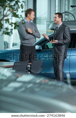 Car salesperson explaining car features to customer