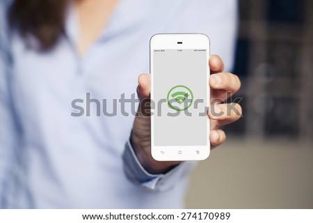 Hand holding a cellphone with wifi generic icon in the screen.