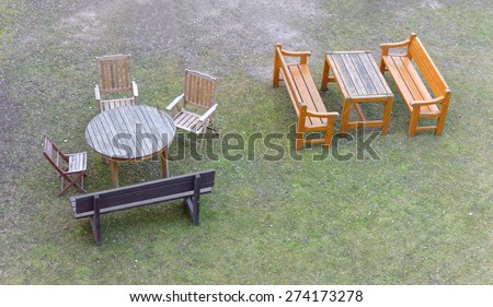 Group of garden furniture seen from above. Two tables, three chairs and two sofas standing on the grass