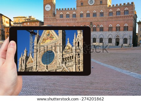 travel concept - tourist takes picture of Cathedral of Siena and Piazza del Campo - Europe's greatest medieval squares, Siena, Italy, on tablet pc