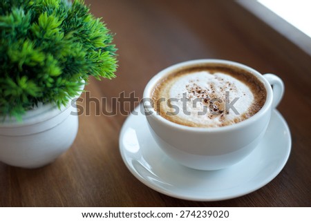 cup of coffee and flower on wood desk