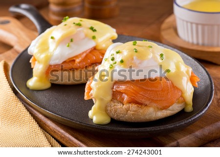 A delicious eggs benedict with smoked salmon, hollandaise sauce, and chives. Royalty-Free Stock Photo #274243001