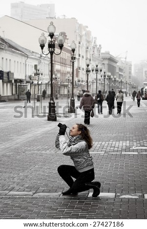 tourist girl taking photos on a street