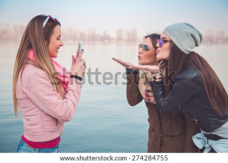 Girlfriends taking a photo of them sending kiss
