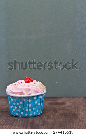 Cupcakes with white cream icing on wooden background