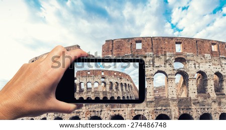 Woman hand with smartphone taking a picture of Colosseum in Rome.
