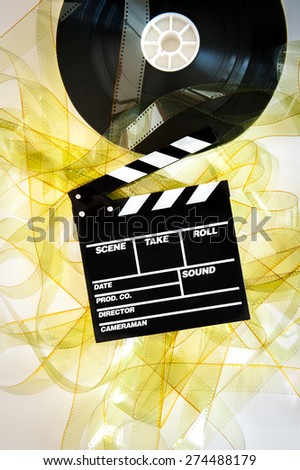 Movie clapper on 35 mm cinema reel unrolled yellow filmstrip on white background vertical
