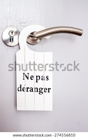 French white signal of  "do not disturb" hanging on a door handle of hotels