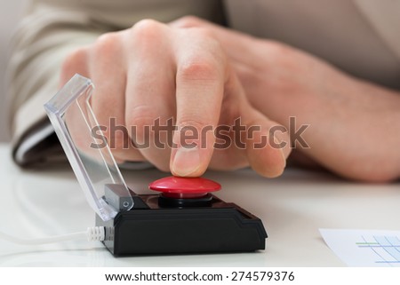 Close-up Of Businessperson Hand Pressing Red Emergency Button