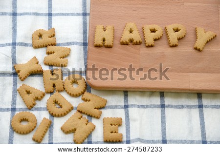 Biscuits ABC in the form of word HAPPY alphabet on wooden background