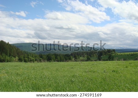 Green hill and blue sky with clouds