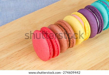 Tasty Sweet Macaroons on wooden background.