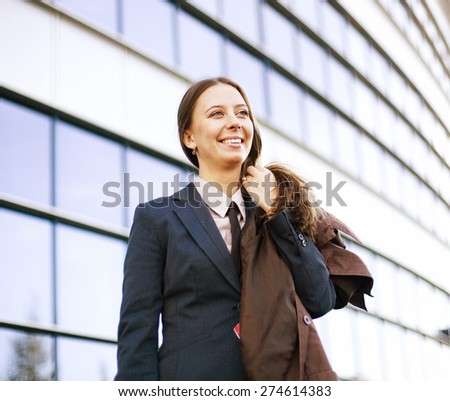 young pretty girl near business building walking, student in america or europe close up smiling