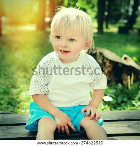 Toned Photo of Cheerful Child on the Bench at the Summer Park