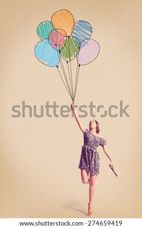 imagination. young woman is flying away with drawn balloons