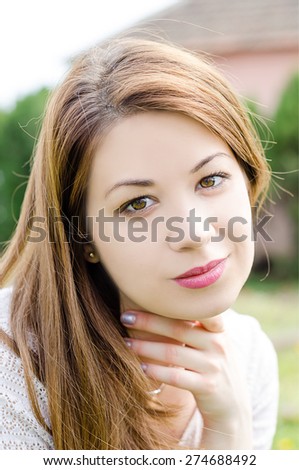 Portrait of a young girl posing outdoors at the park. Natural light portrait.