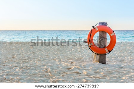 Life preserver on sandy beach somewhere in Mexico Royalty-Free Stock Photo #274739819