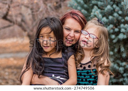 Mother playing with her young daughters outside at a park in Reno, Nevada, USA. 