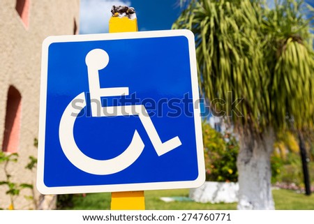 Blue handicapped sign with wheelchair, outdoors
