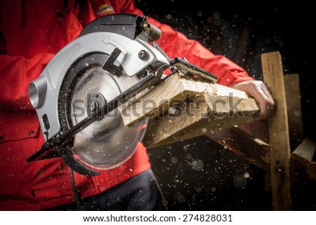 Close-up of carpenter cutting a wooden plank  Royalty-Free Stock Photo #274828031