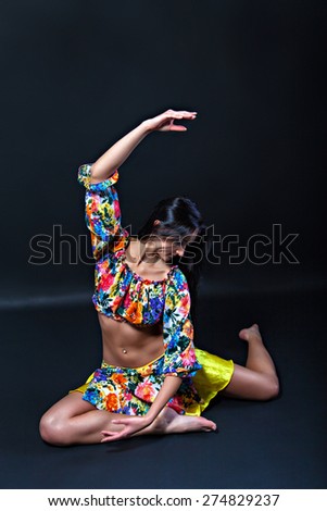 Pretty brunette woman in colorful costume dancing