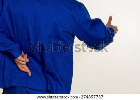 a craftsman crossed fingers behind his back. falsehood and untruth in the commercial. Royalty-Free Stock Photo #274857737
