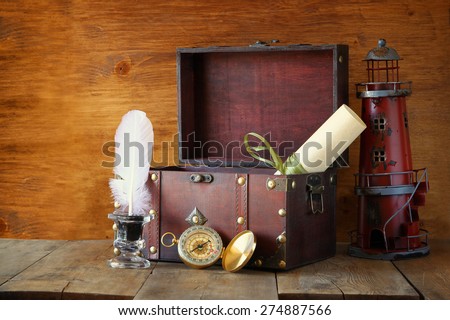 antique compass, inkwell and old wooden chest  on wooden table. black and white style old photo