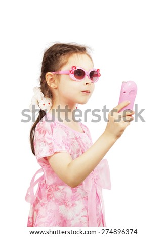 Little pretty girl with pink sunglasses holds toy mobile